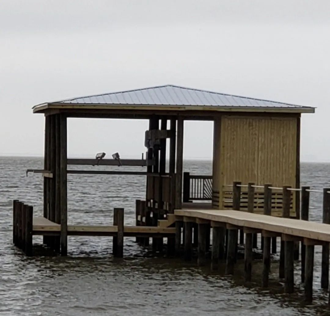 A wooden dock with a roof overlooking the ocean