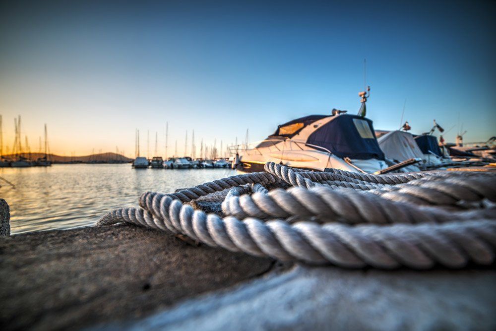 A bunch of ropes are tied to a boat in a harbor.