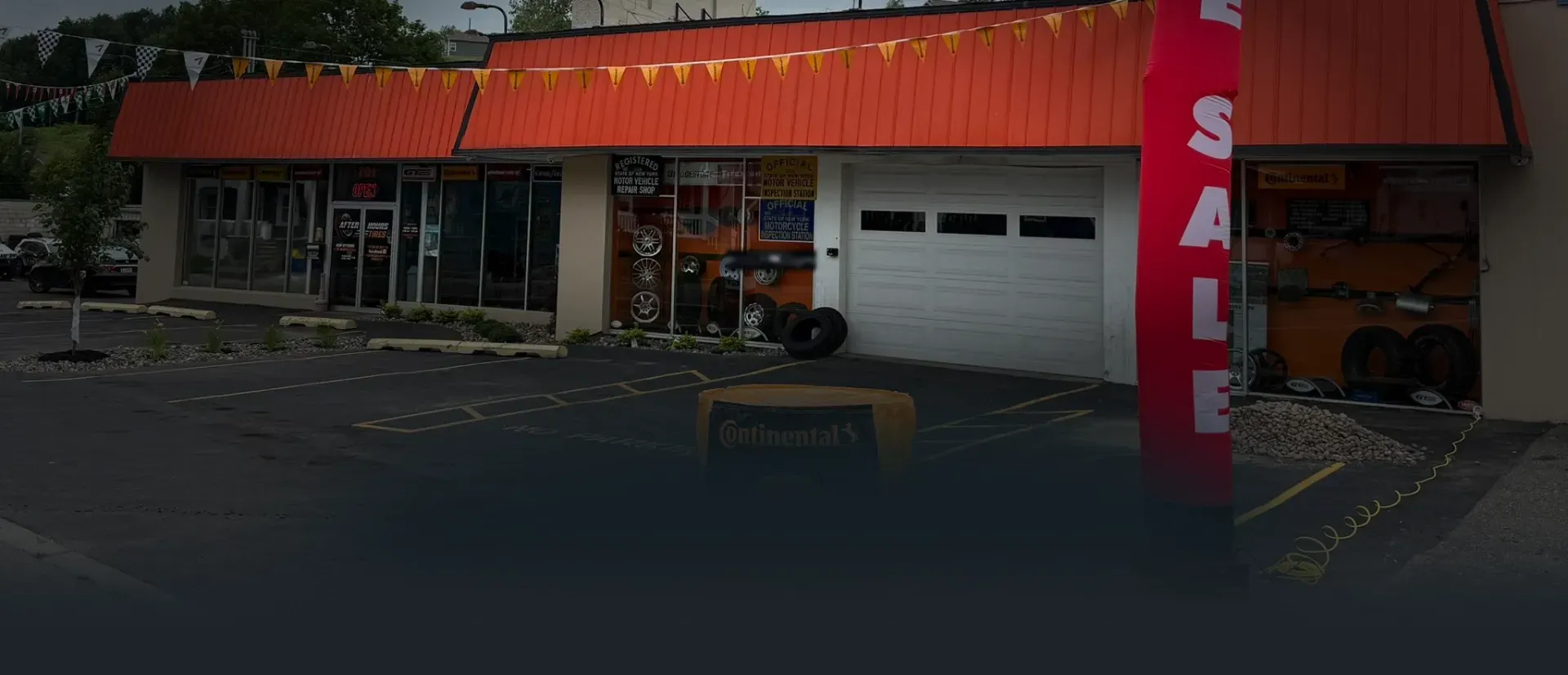 Outside of our shop with Tire Sale Inflatable man | After Hours Tires