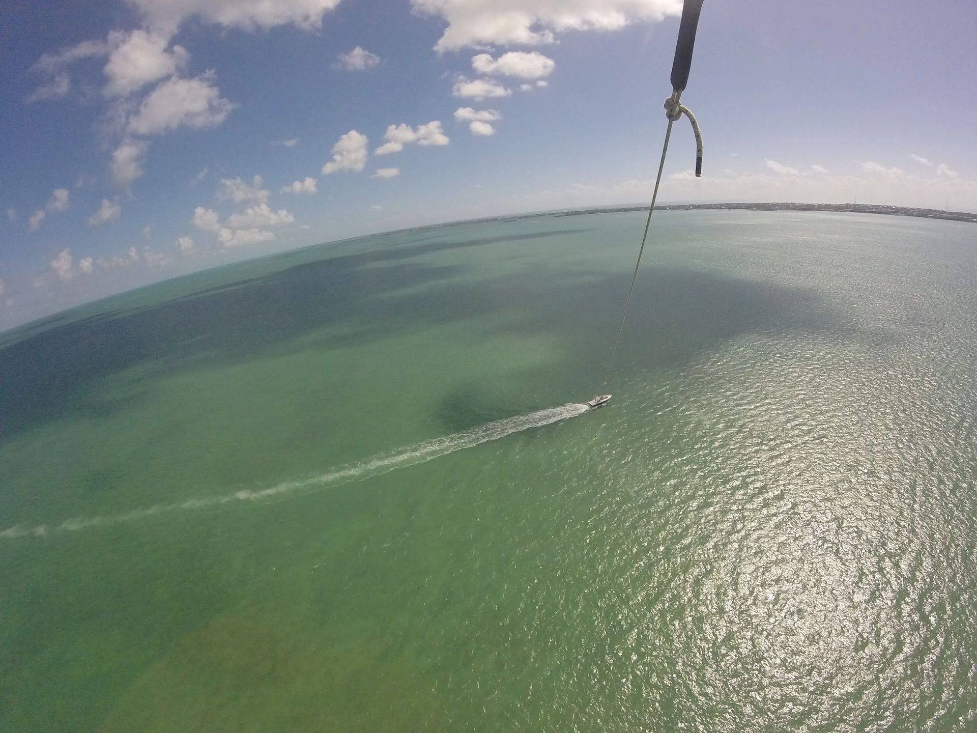 A person is parasailing over a body of water
