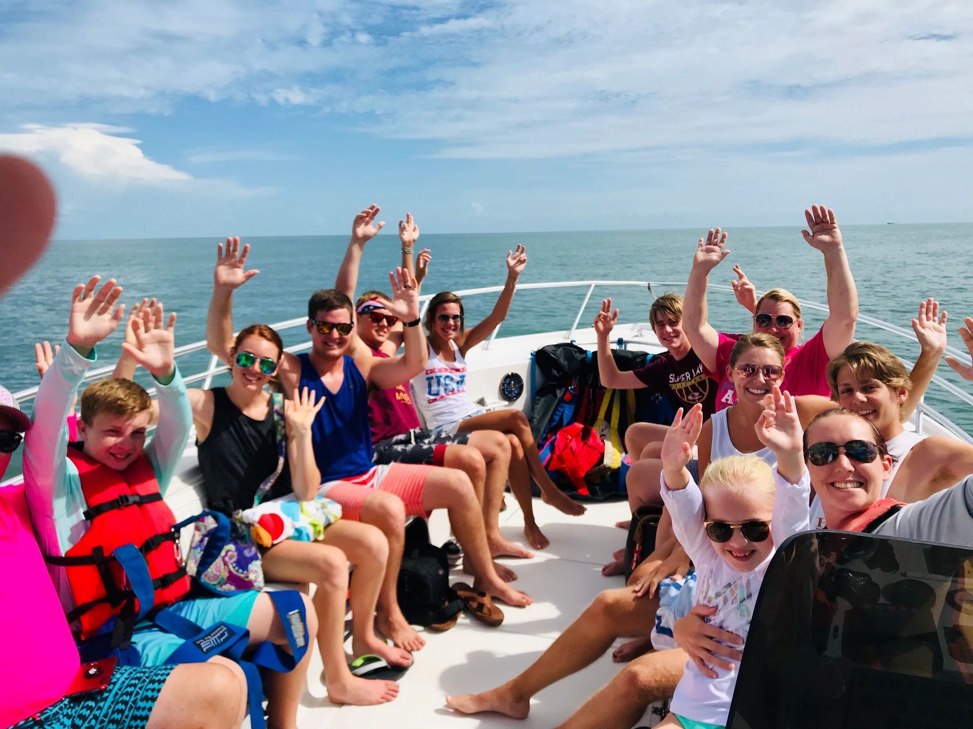 A group of people are sitting on a boat in the ocean.