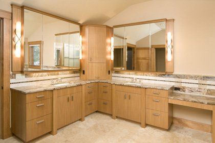 wooden cabinets installed in the bathroom with mirror and lighting