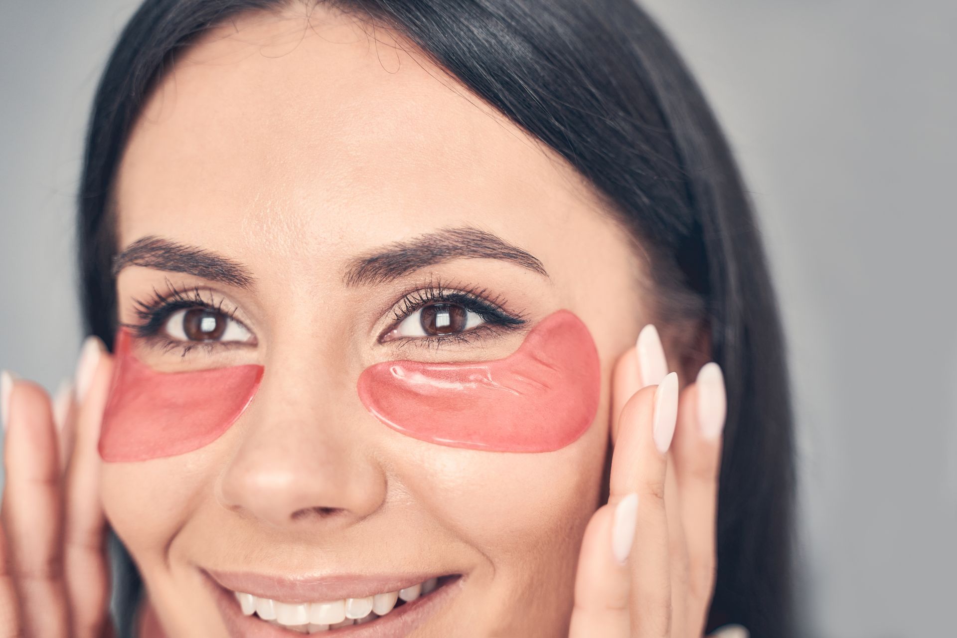 woman smiling with under eye masks on