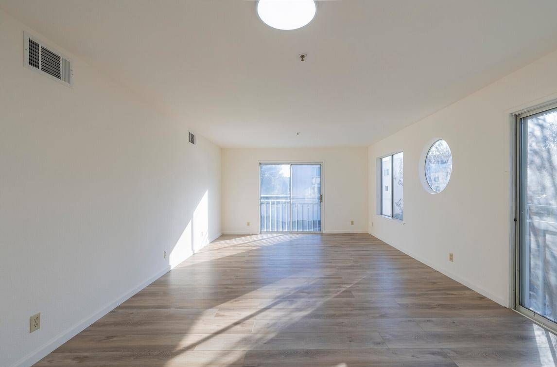 Photo showing a large living room with 4 separate windows for distinct natural lighting