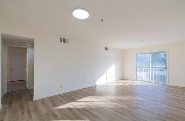 Photo showing a large living room with the hallway in the background to the left