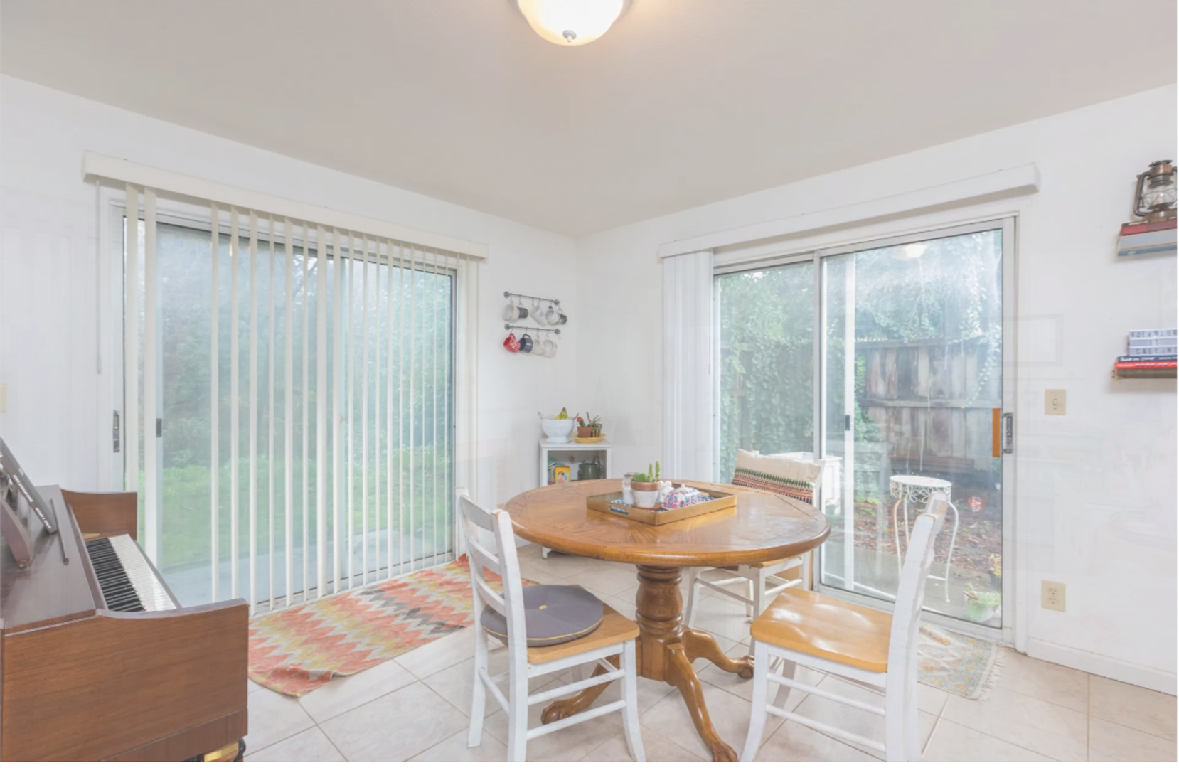 Photo showing the dining area of an apartment with plenty of natural lighting from two separate sliding glass doors
