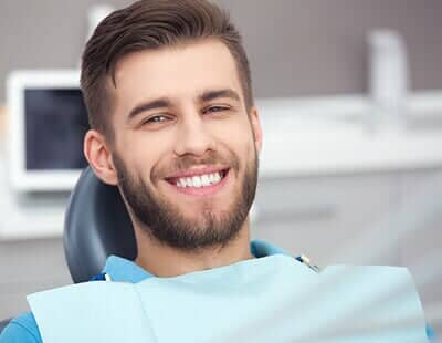 Portrait of happy patient in dental chair — Orthodontics in Owosso, MI