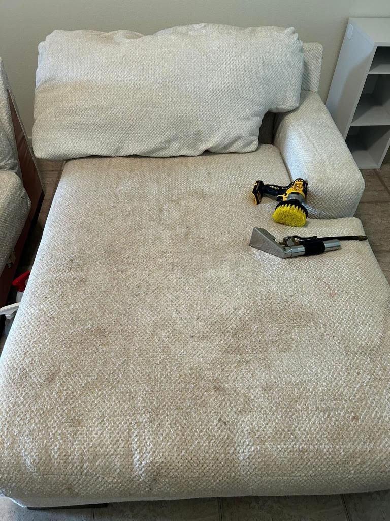 A white couch is sitting on a tiled floor in a living room.