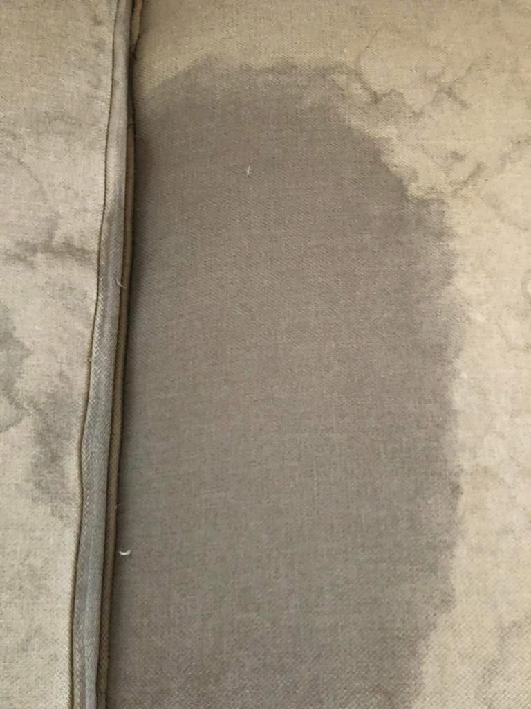 A close up of a carpet with a stain on it.