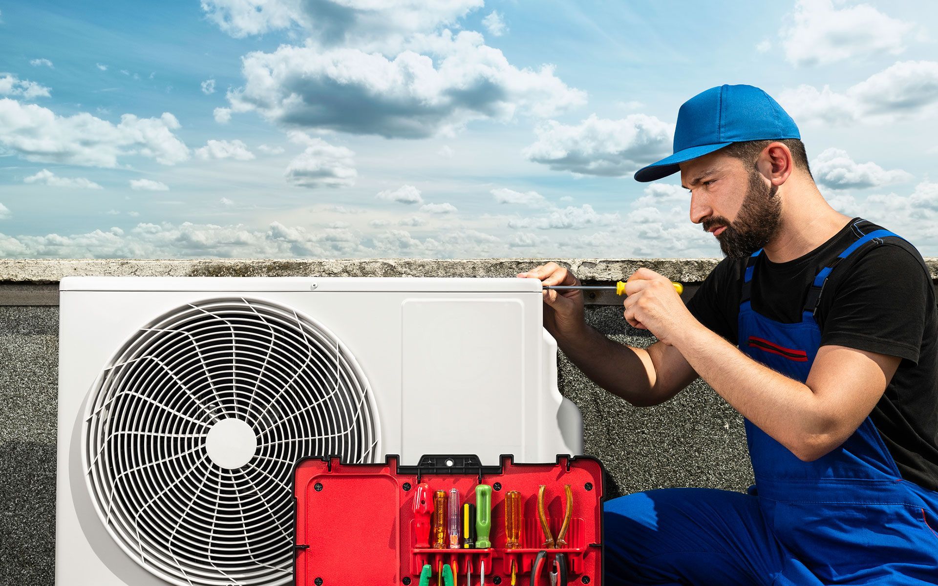 A man is fixing an air conditioner on a roof.