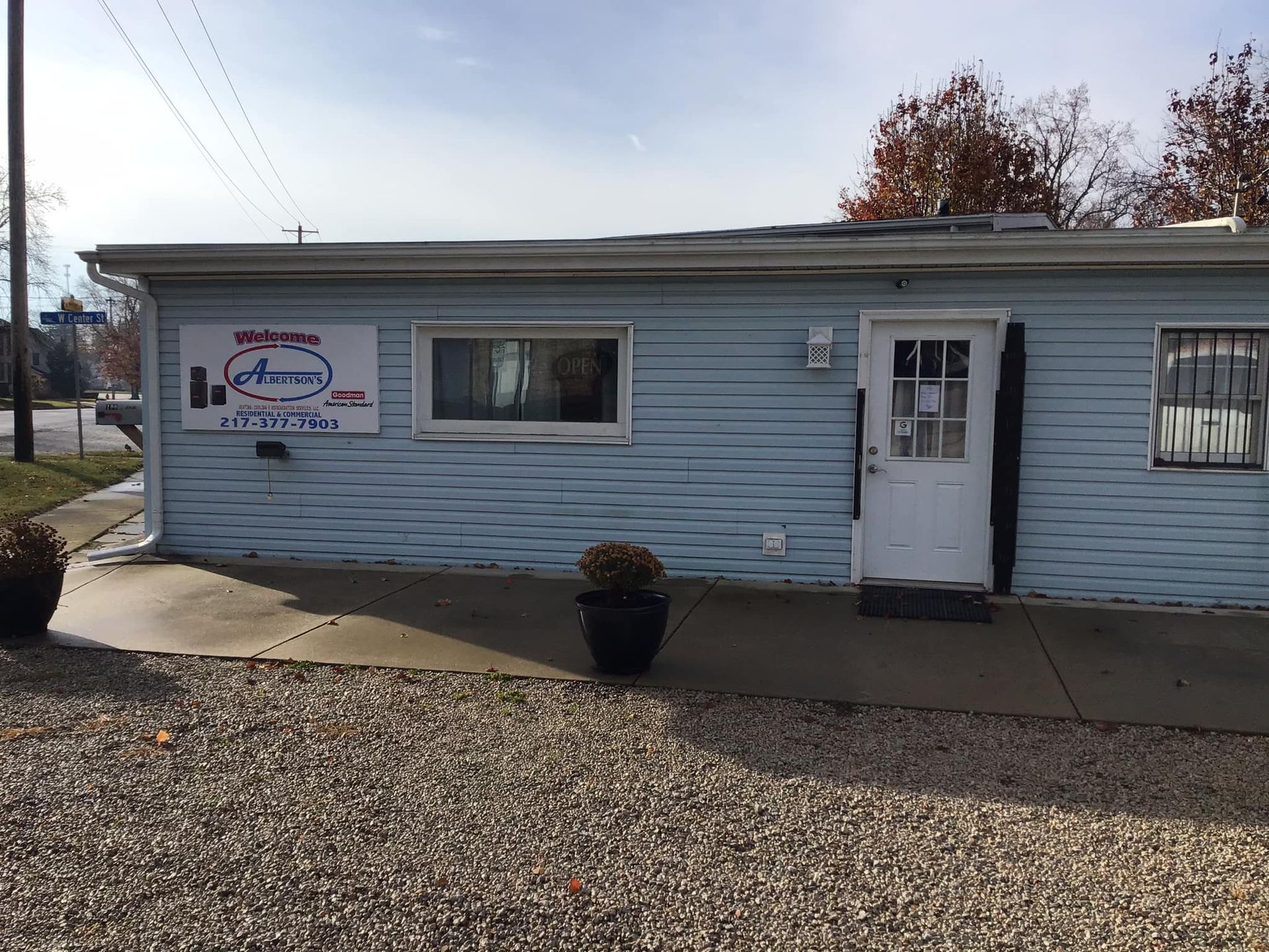 A blue building with a white door and a sign that says ' aurora ' on it