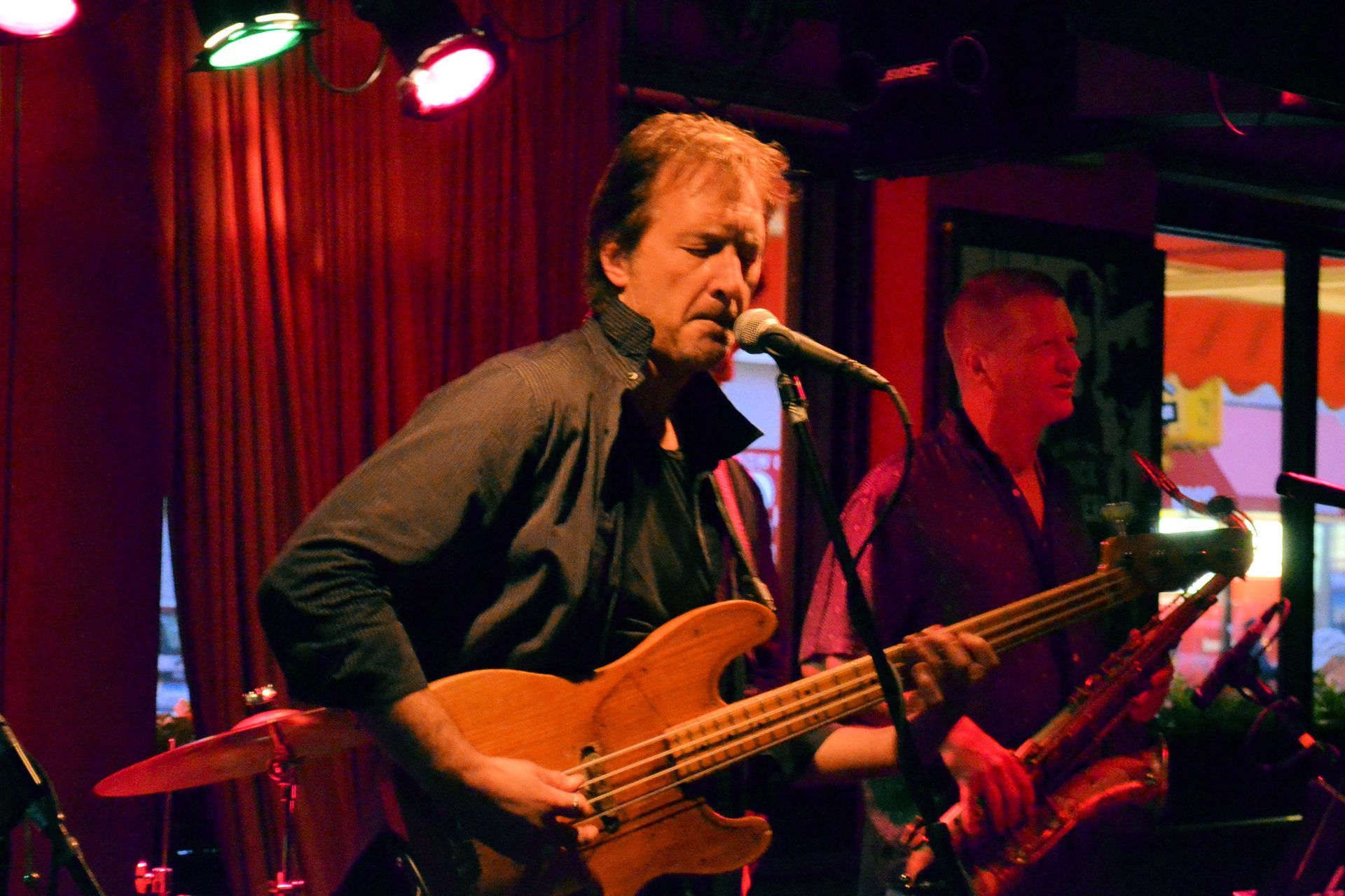 Matt Feinberg singing into a microphone while playing a guitar .