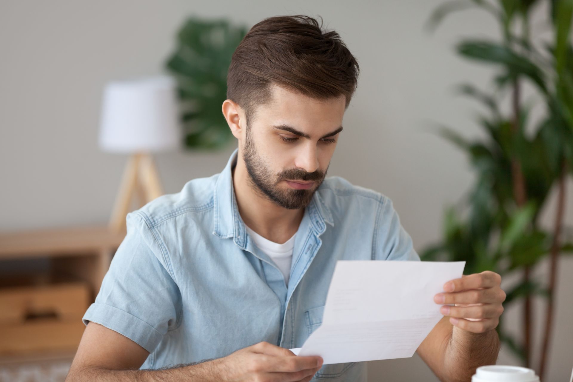 Teenager seated on a floor cushion smiles at an adult. The adult writes on a pad in a brightly lit room.