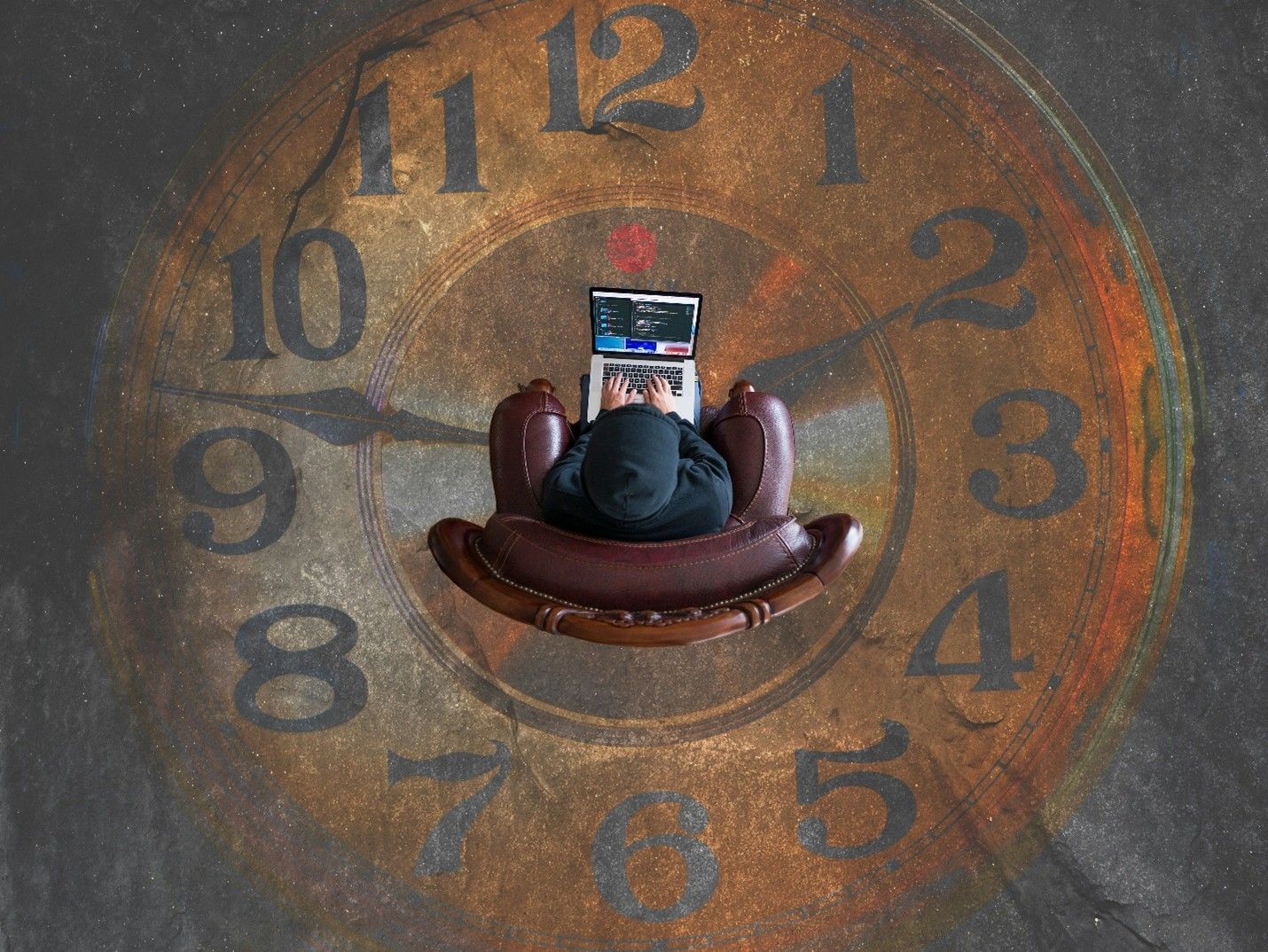 Person seated in a brown chair beneath a large clock face on a gray floor