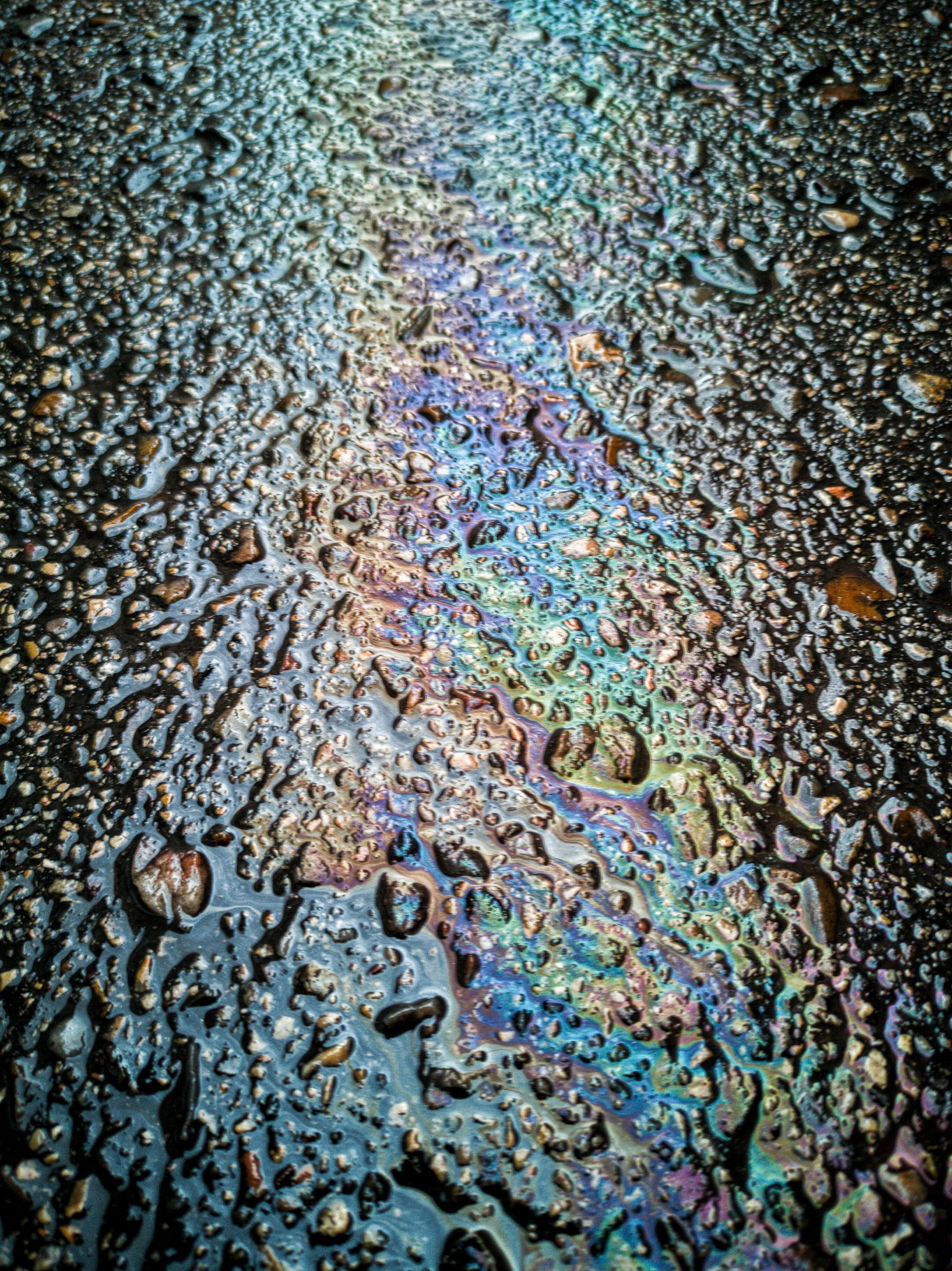 A close up of a rainbow of oil on the ground.