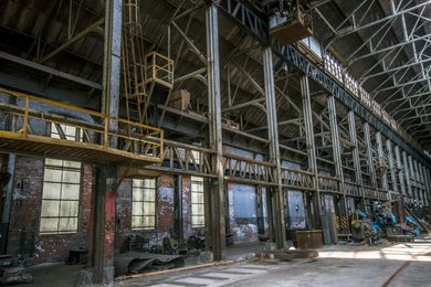A large warehouse with a lot of columns and a lot of windows.