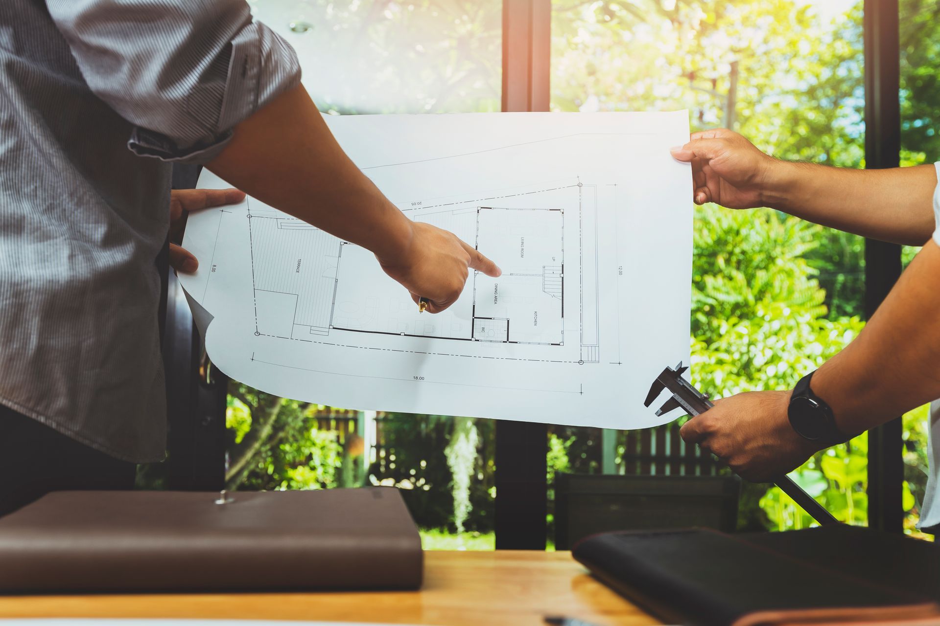 Two men are looking at a blueprint of a house.