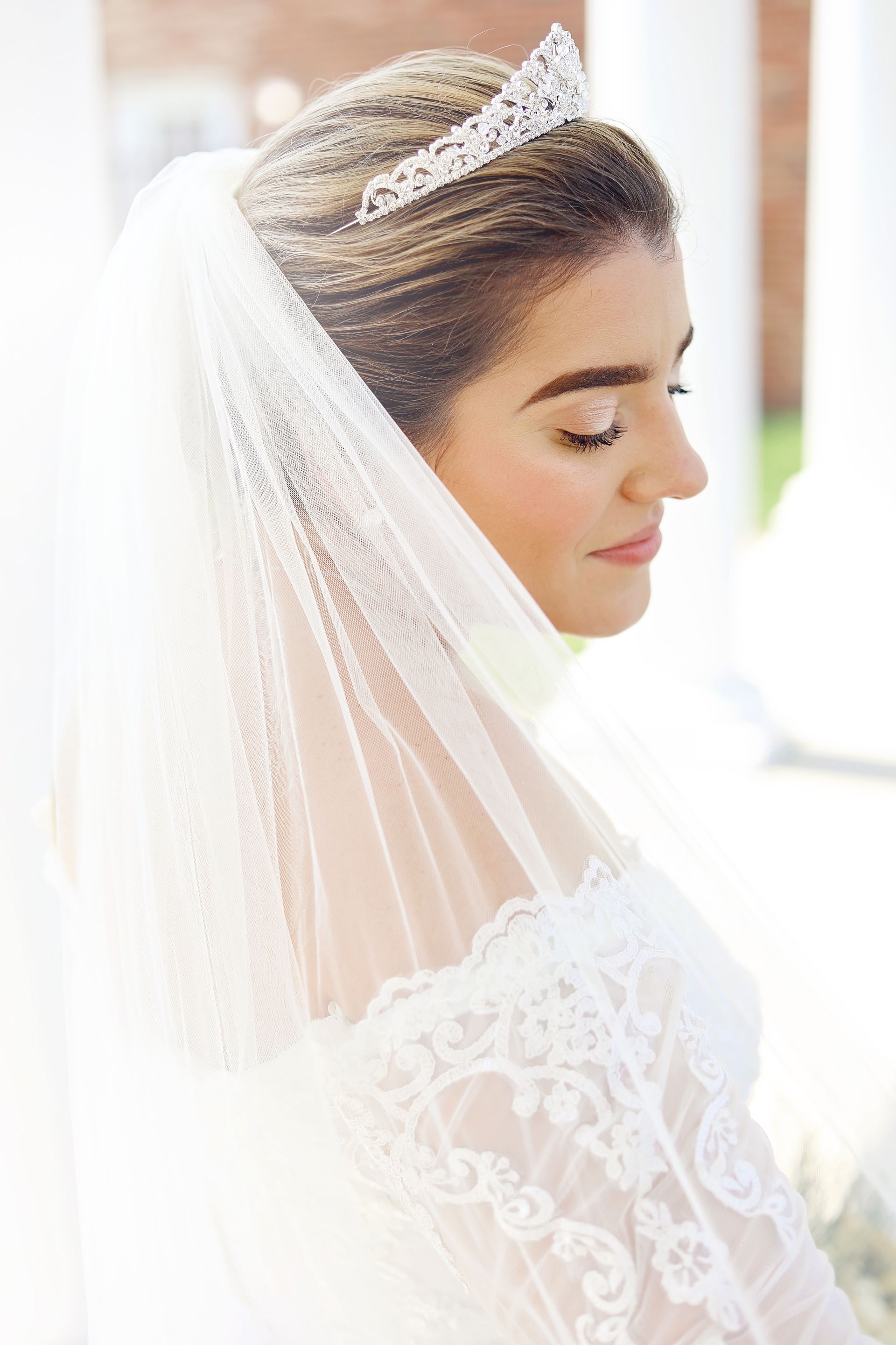 The bride is wearing a veil and a tiara.