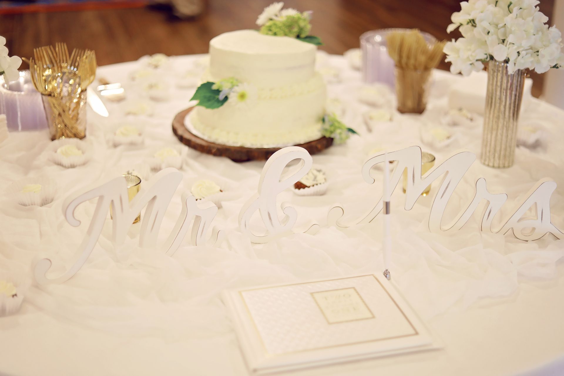 A wedding cake is on a table with a sign that says mr. and mrs.