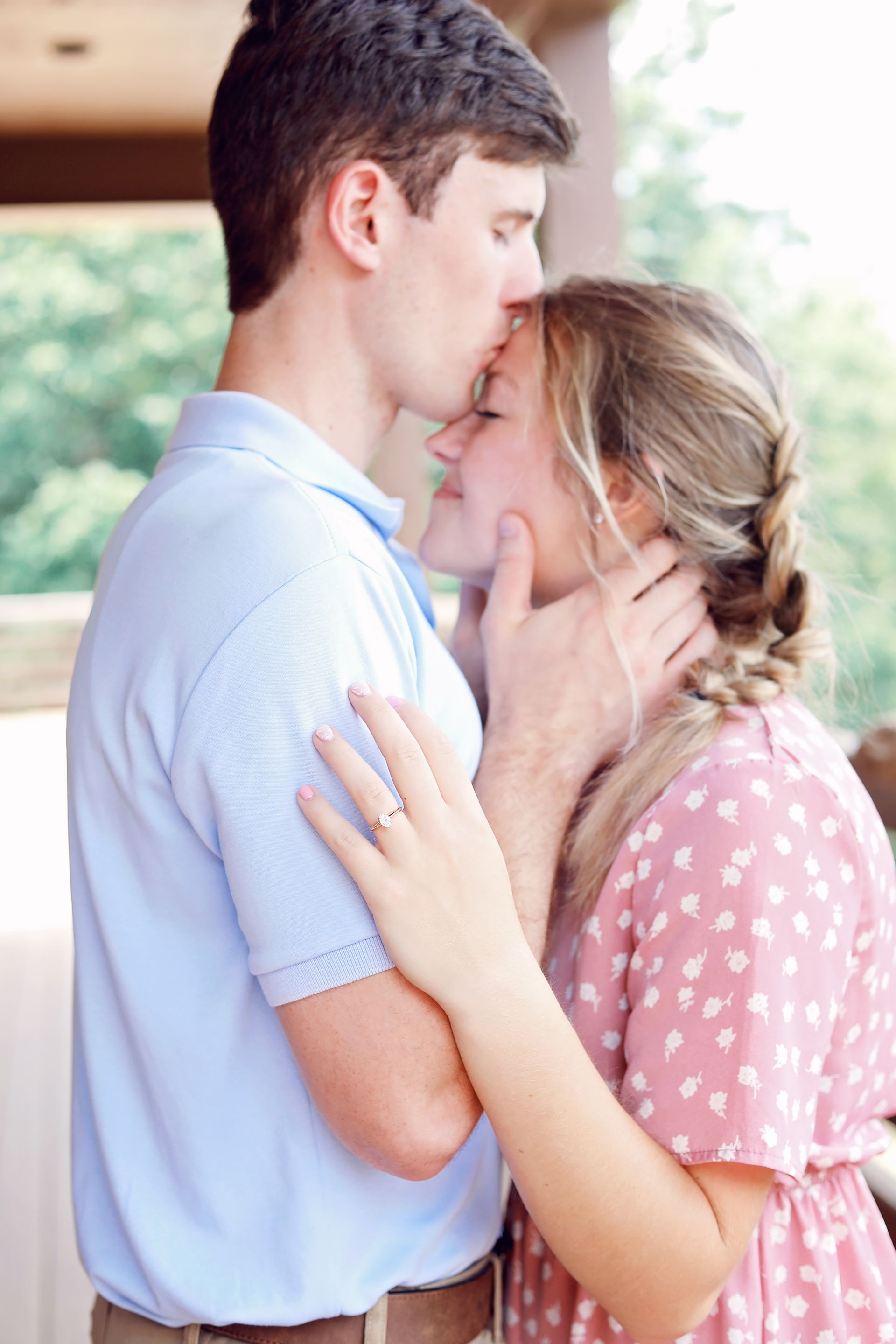 A man is kissing a woman on the forehead.