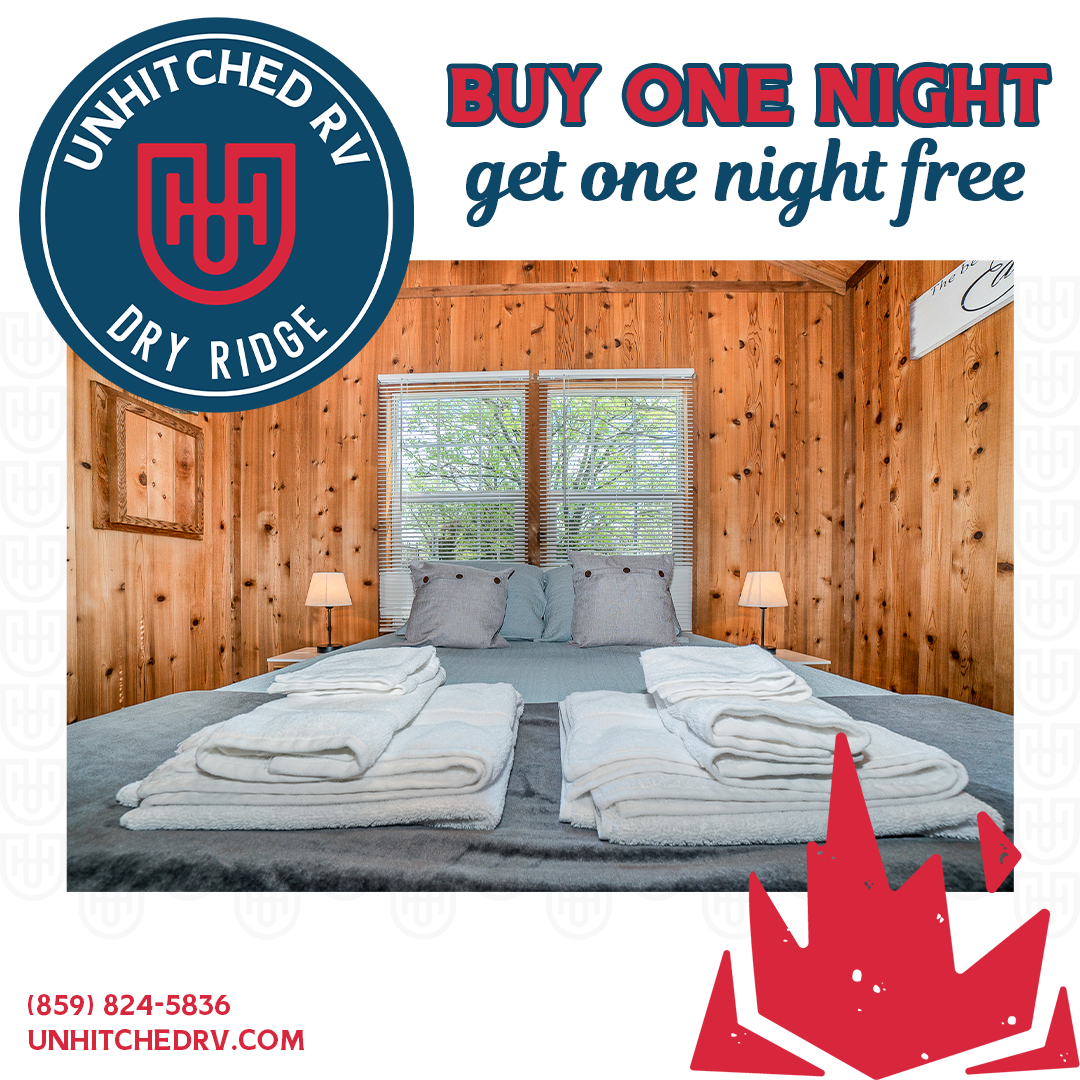 RV rental ad: Bedroom with buy-one-get-one-free promotion. Wooden panel walls, bed with white linens, logo.