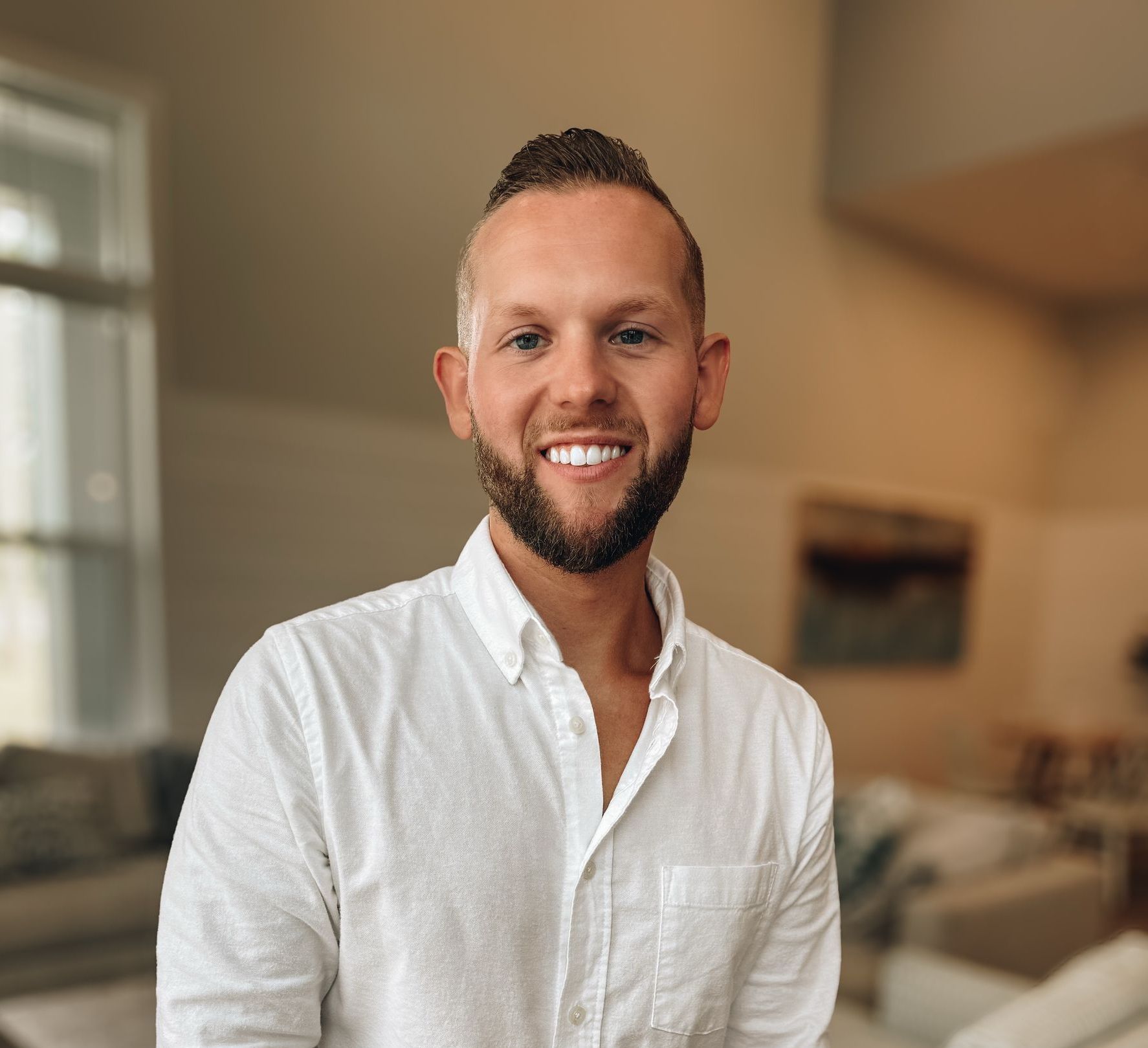A man in a white shirt and tie is smiling for the camera.
