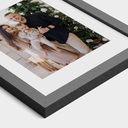 A framed picture of a family standing in front of a christmas tree