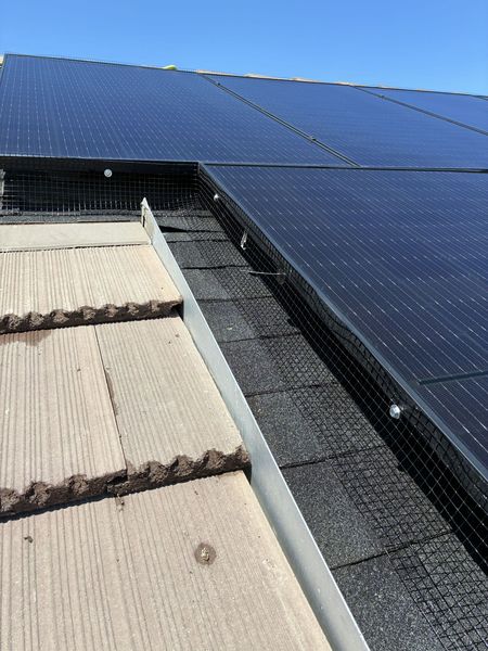 Solar panels installed on a tiled roof, with a metal flashing along the edge.