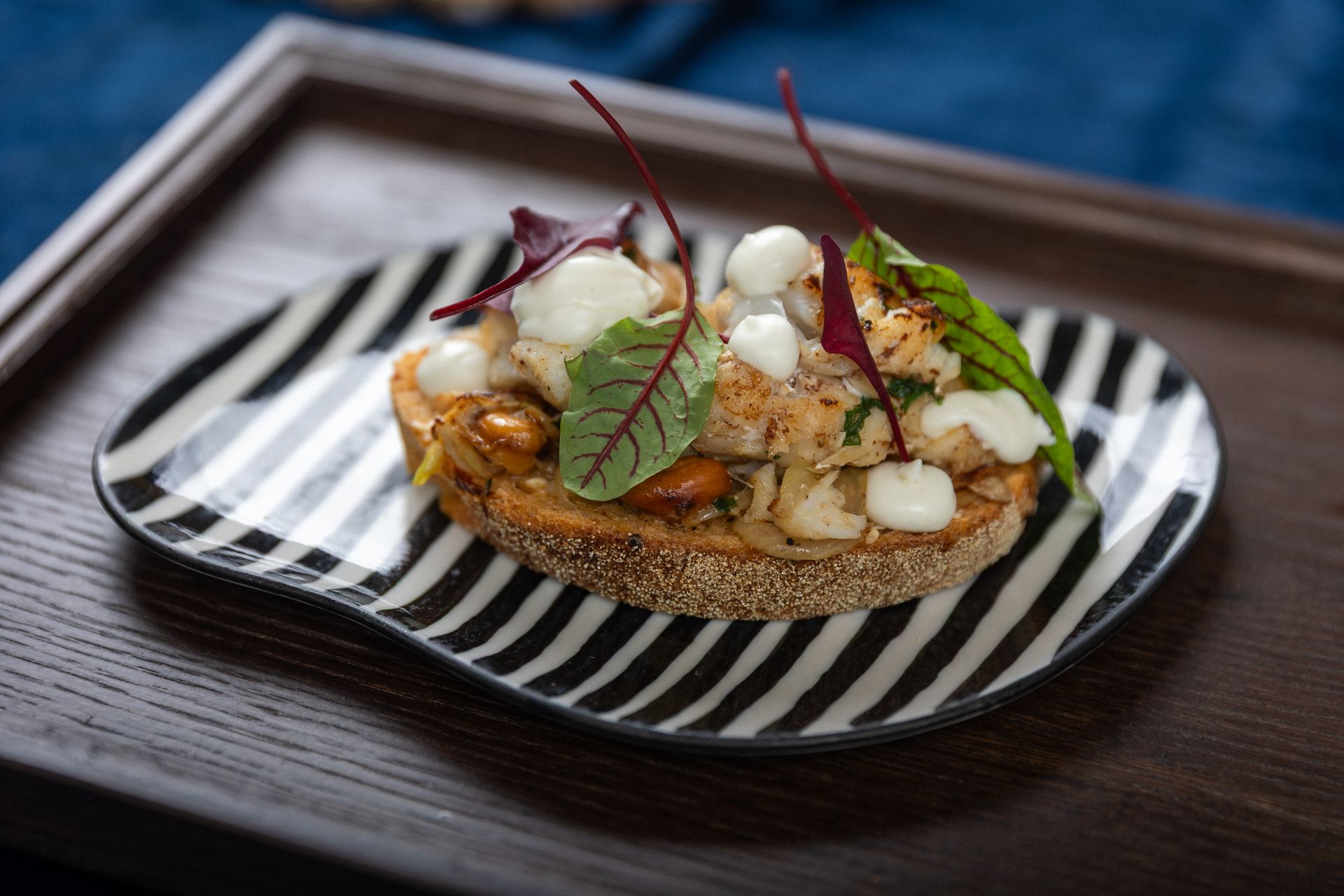 Bragðmiklir þorskbitar steiktir með döðlum, hnetum og hvítlauk – bornir fram á nýbökuðu brauði.