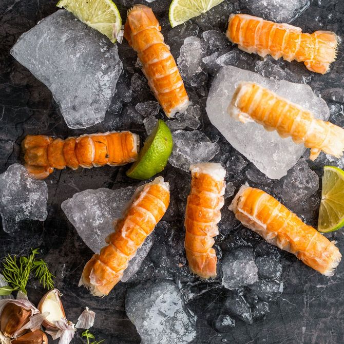 Eldaðir humarhalar á ís með límónusneiðum.