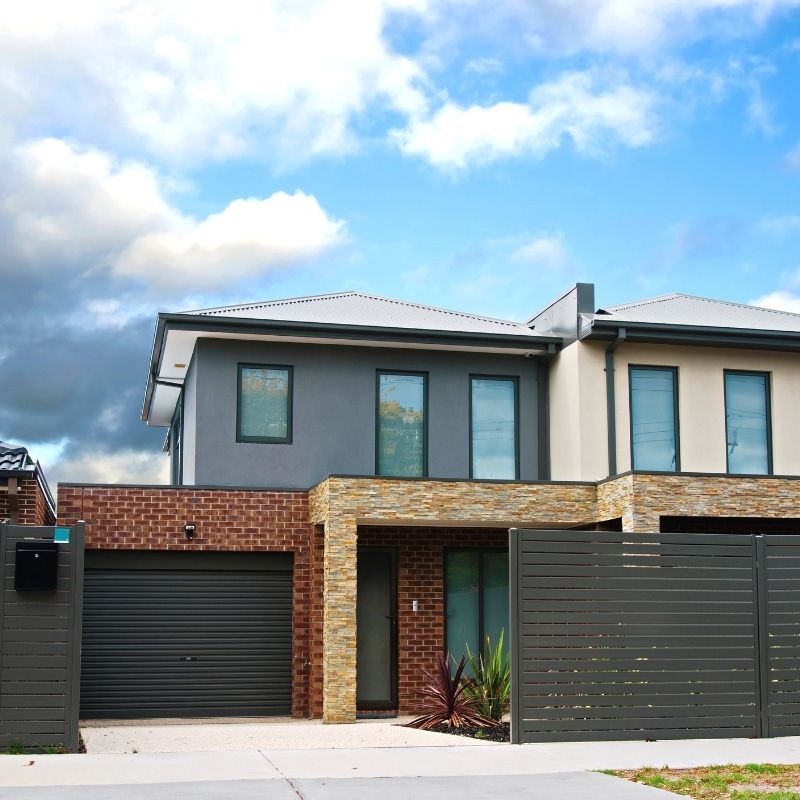 A House With A Brick Facade And A Black Garage Door — North Ballina Windows In Bangalow, NSW
