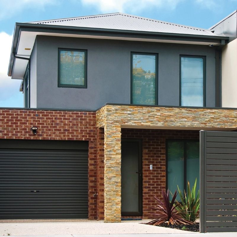 A Brick House With A Black Garage Door — North Ballina Windows In Tweed Heads, NSW