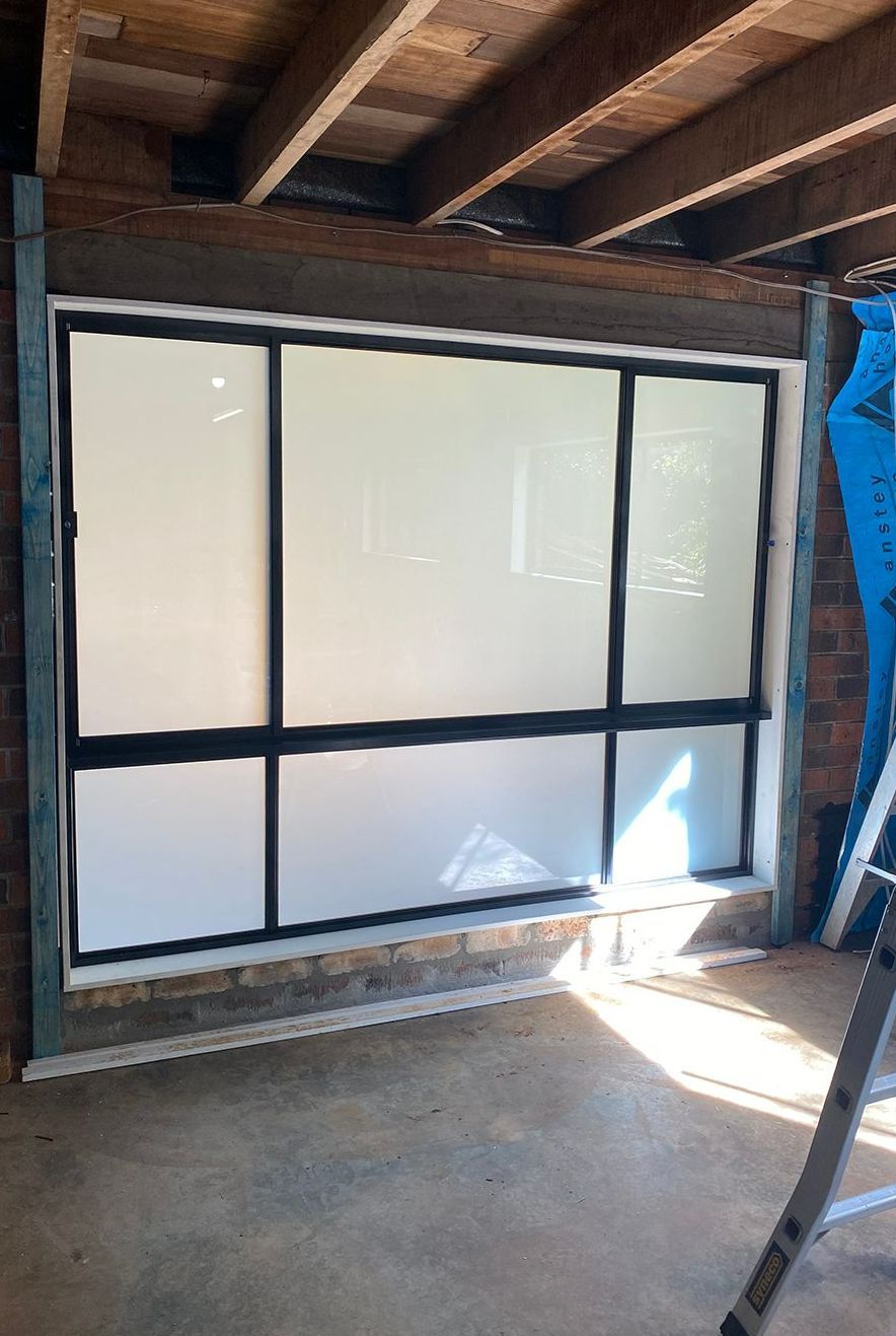A Large Frosted Window Is Being Installed In A Room — North Ballina Windows In Ocean Shores, NSW