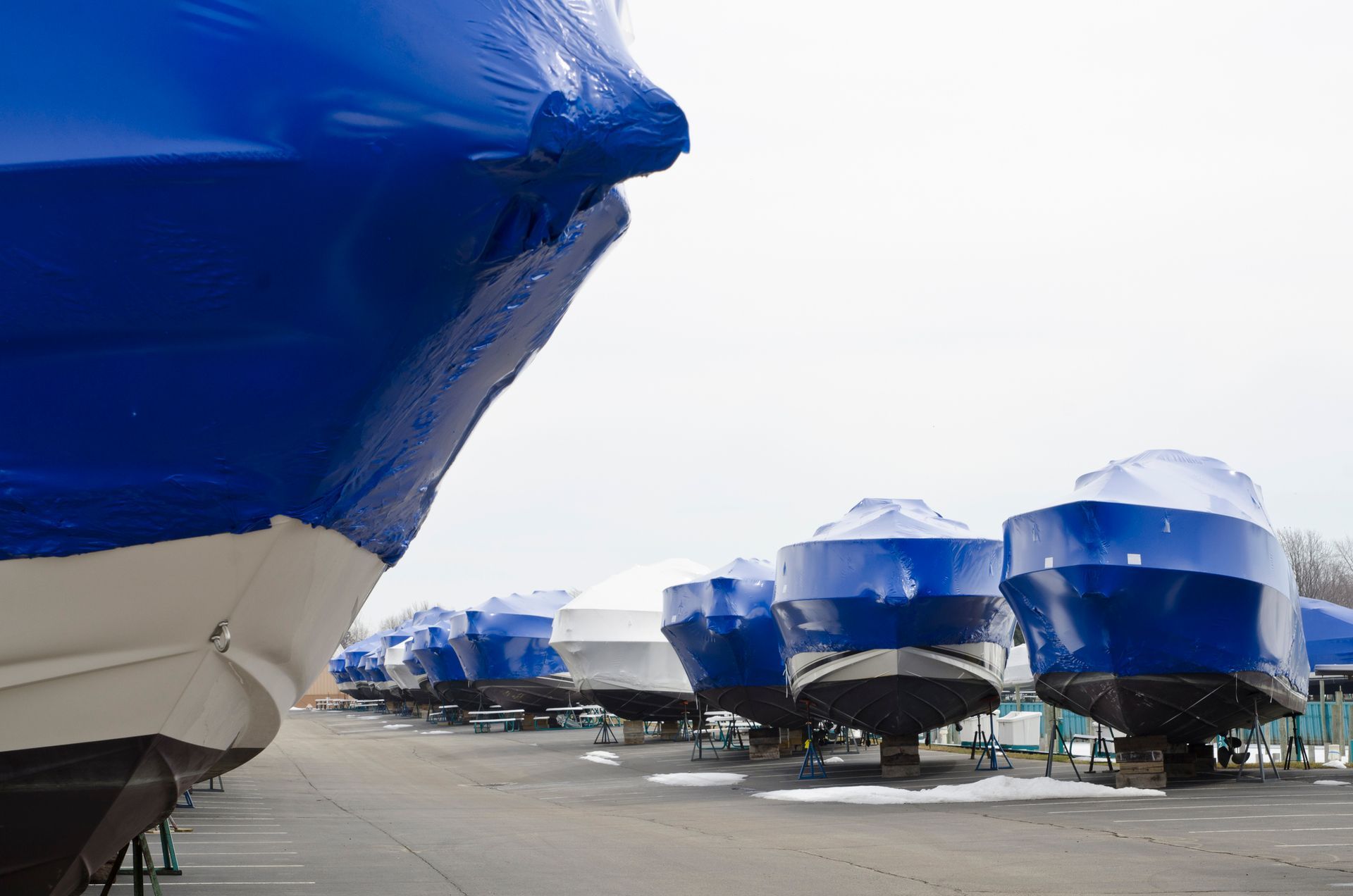 Covered boats in marina storage with shrink wrap for winter protection. Covered boats in marina storage with shrink wrap for winter protection.