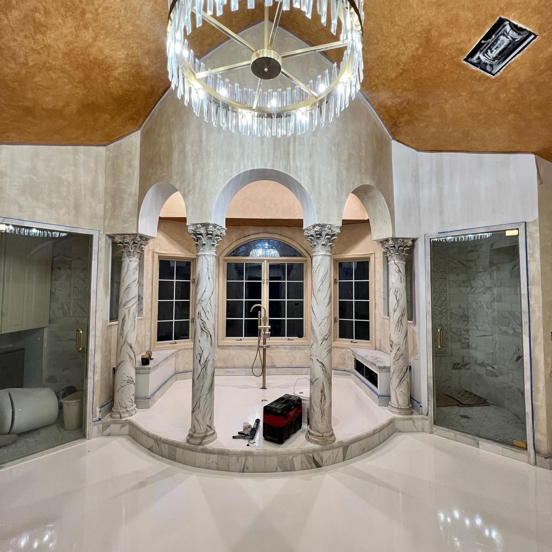 WCL ConstructionPaint Carpentry Inc - A bathroom with a large chandelier hanging from the ceiling