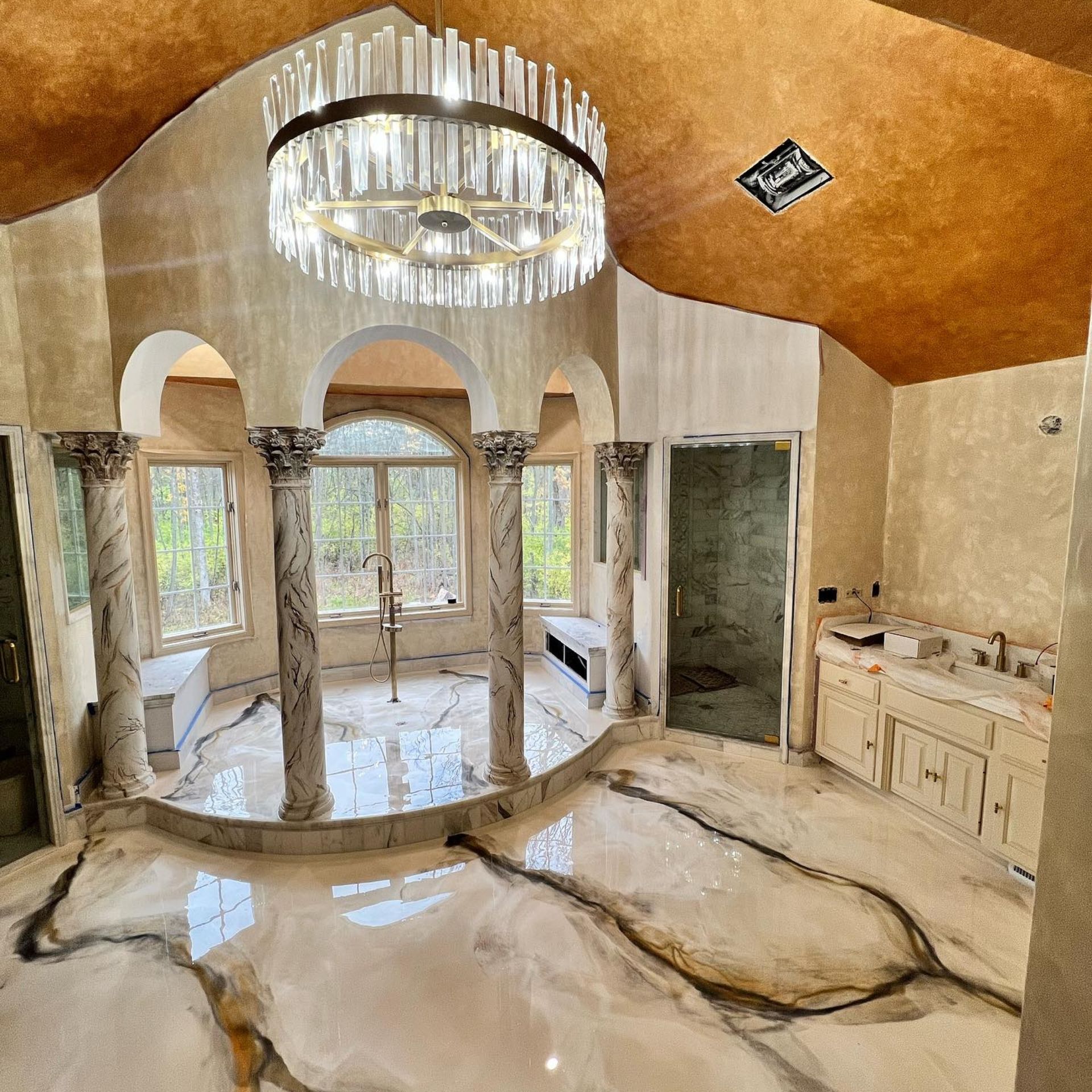 WCL Construction/Paint & Carpentry Inc - A bathroom with a large chandelier hanging from the ceiling