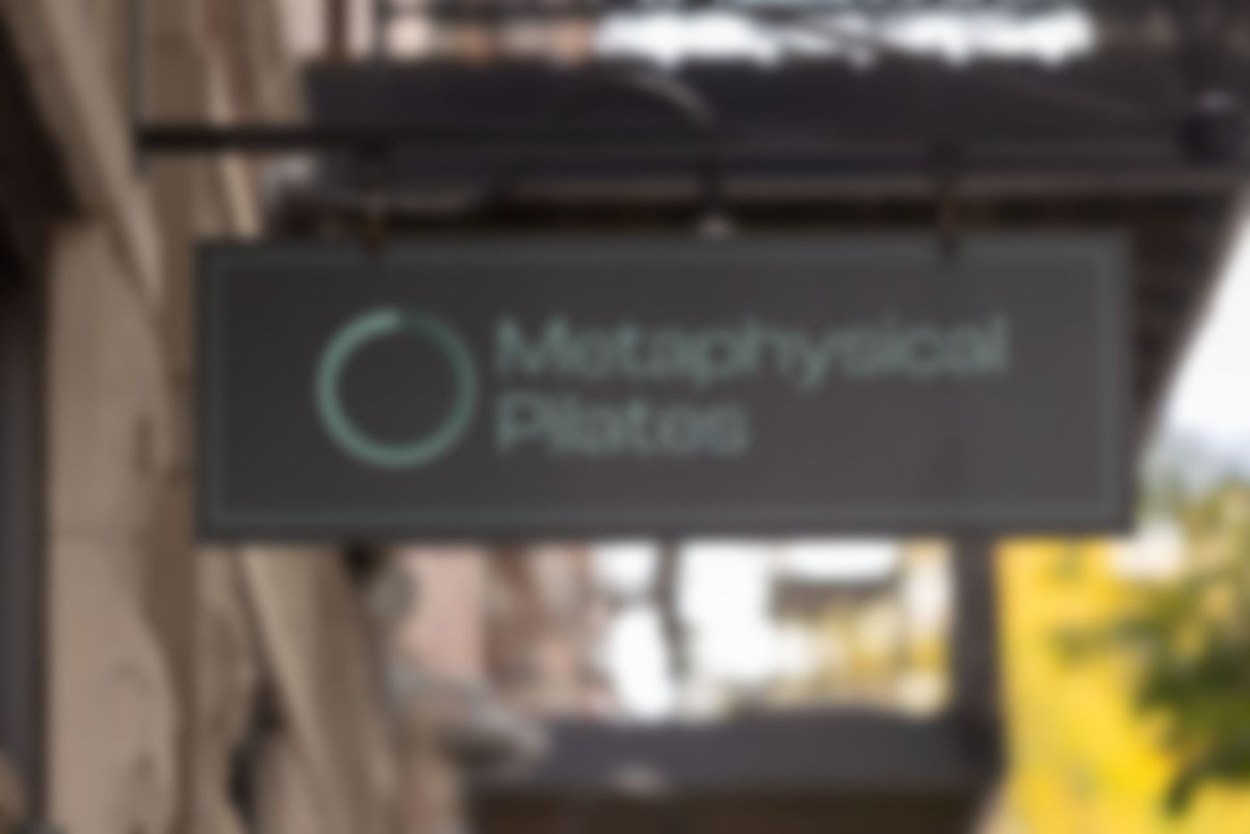 blurred image of the a sign that reads Metaphysical Pilates