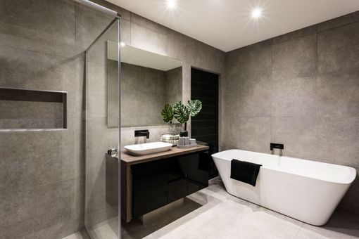 Modern bathroom with a freestanding tub, vanity, and glass shower, finished in gray stone tiles. Modern bathroom with a freestanding tub, vanity, and glass shower, finished in gray stone tiles.