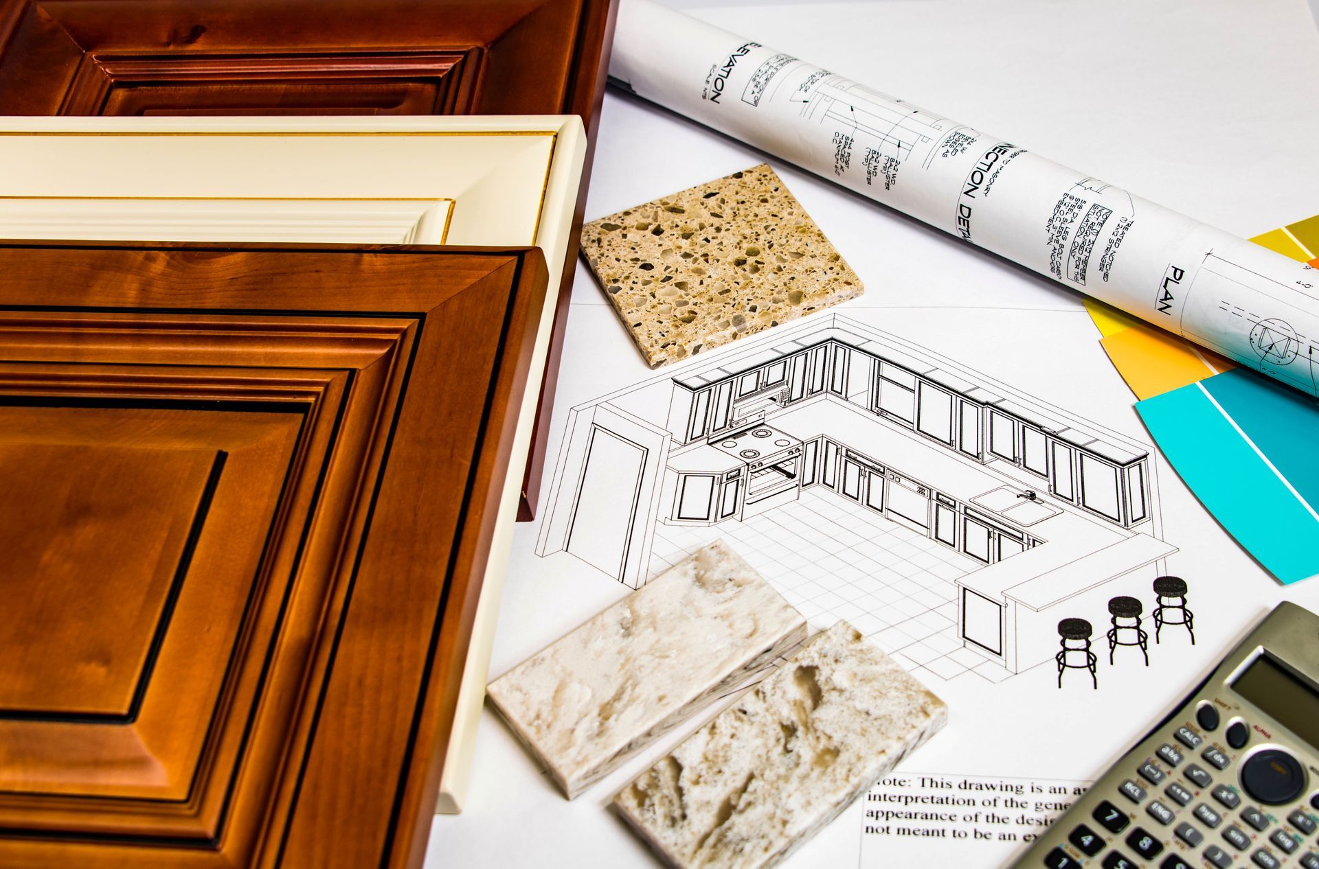 Architectural materials with wood samples, floor plans, stone tiles, and a calculator on a desk Architectural materials with wood samples, floor plans, stone tiles, and a calculator on a desk
