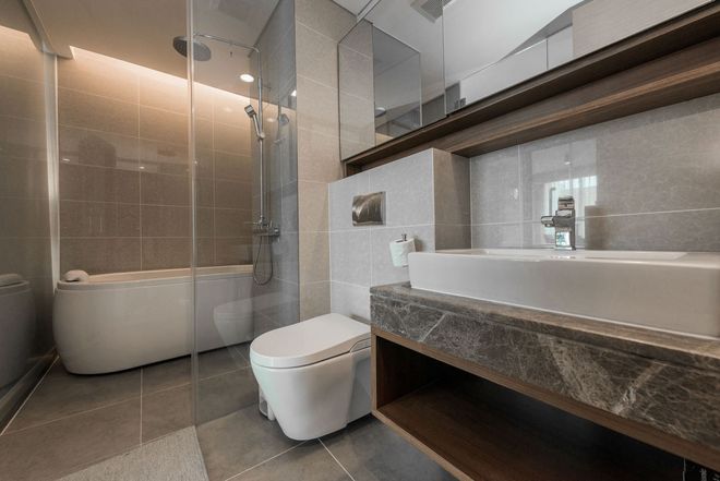 Modern bathroom with bathtub, toilet, and dark stone vanity with large mirror Modern bathroom with bathtub, toilet, and dark stone vanity with large mirror