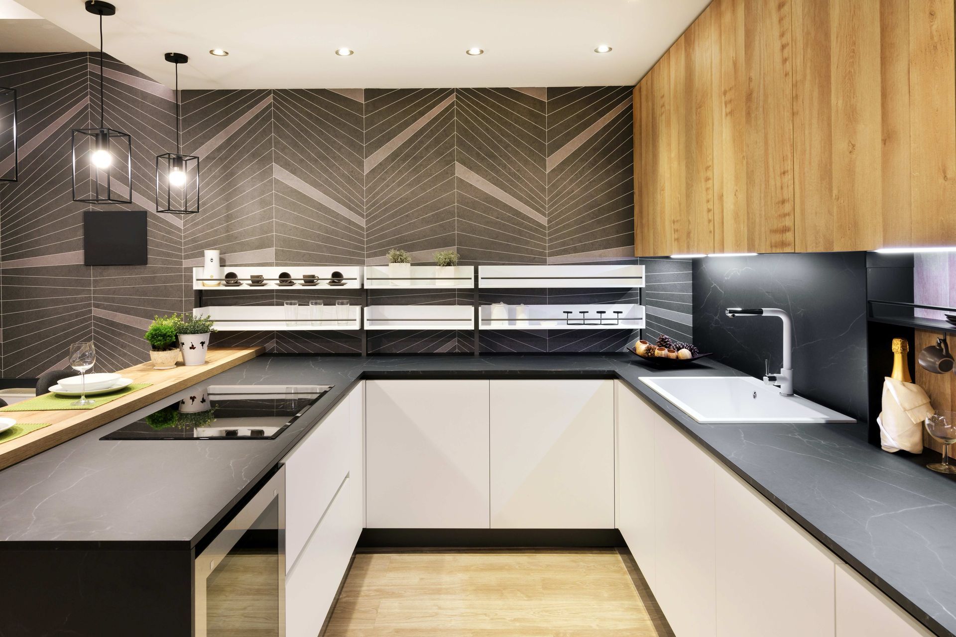 Modern kitchen with black countertops, white cabinets, wood accents, and herringbone tile backsplash Modern kitchen with black countertops, white cabinets, wood accents, and herringbone tile backsplash