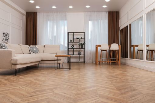 Bright modern living room with sofa, coffee table, dining set, and herringbone wood floor Bright modern living room with sofa, coffee table, dining set, and herringbone wood floor