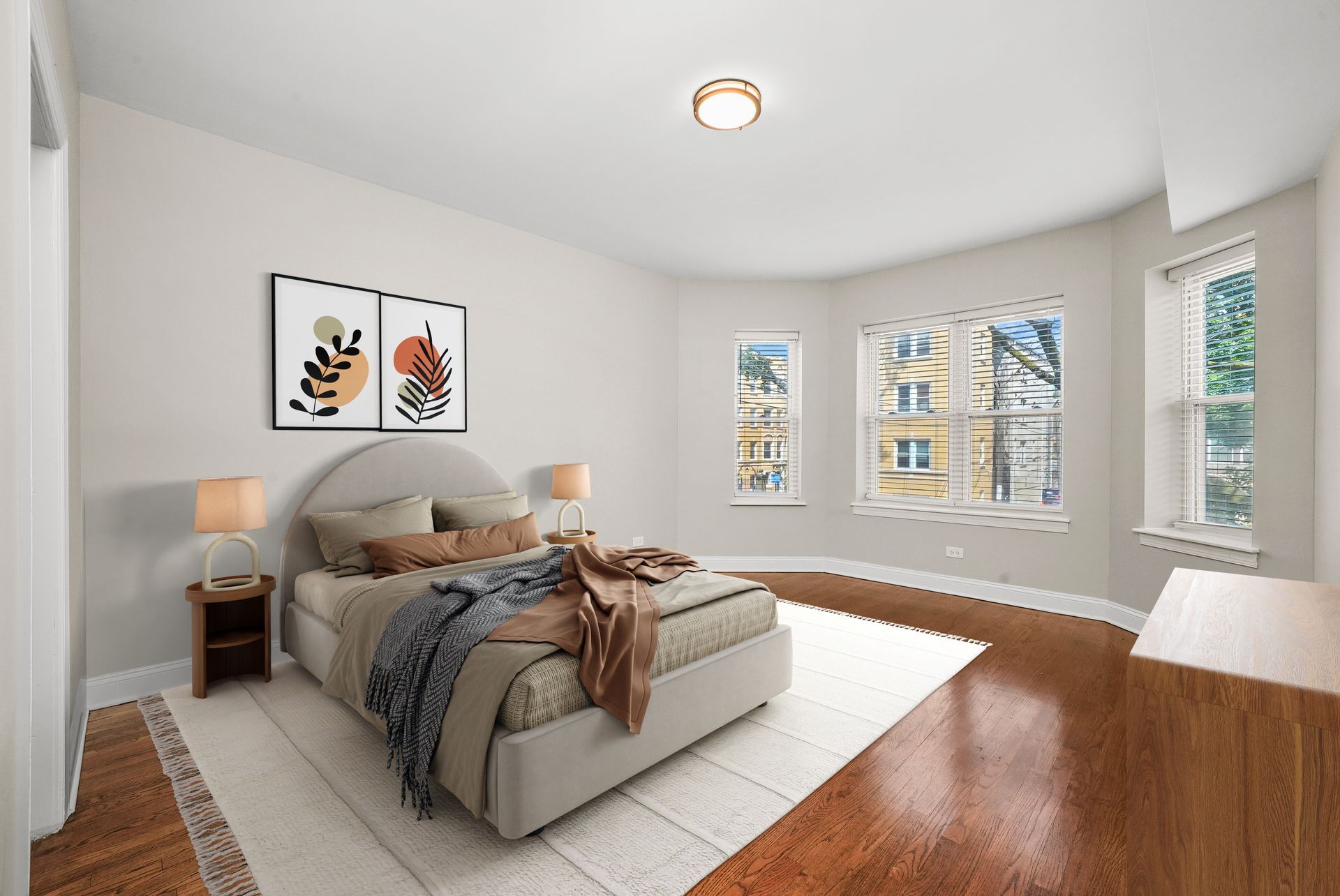 Bedroom with beige walls, hardwood floors, a bed, artwork, and a window.