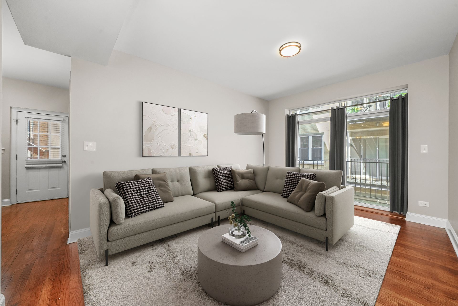 Living room with sectional sofa, coffee table, rug, and large windows.