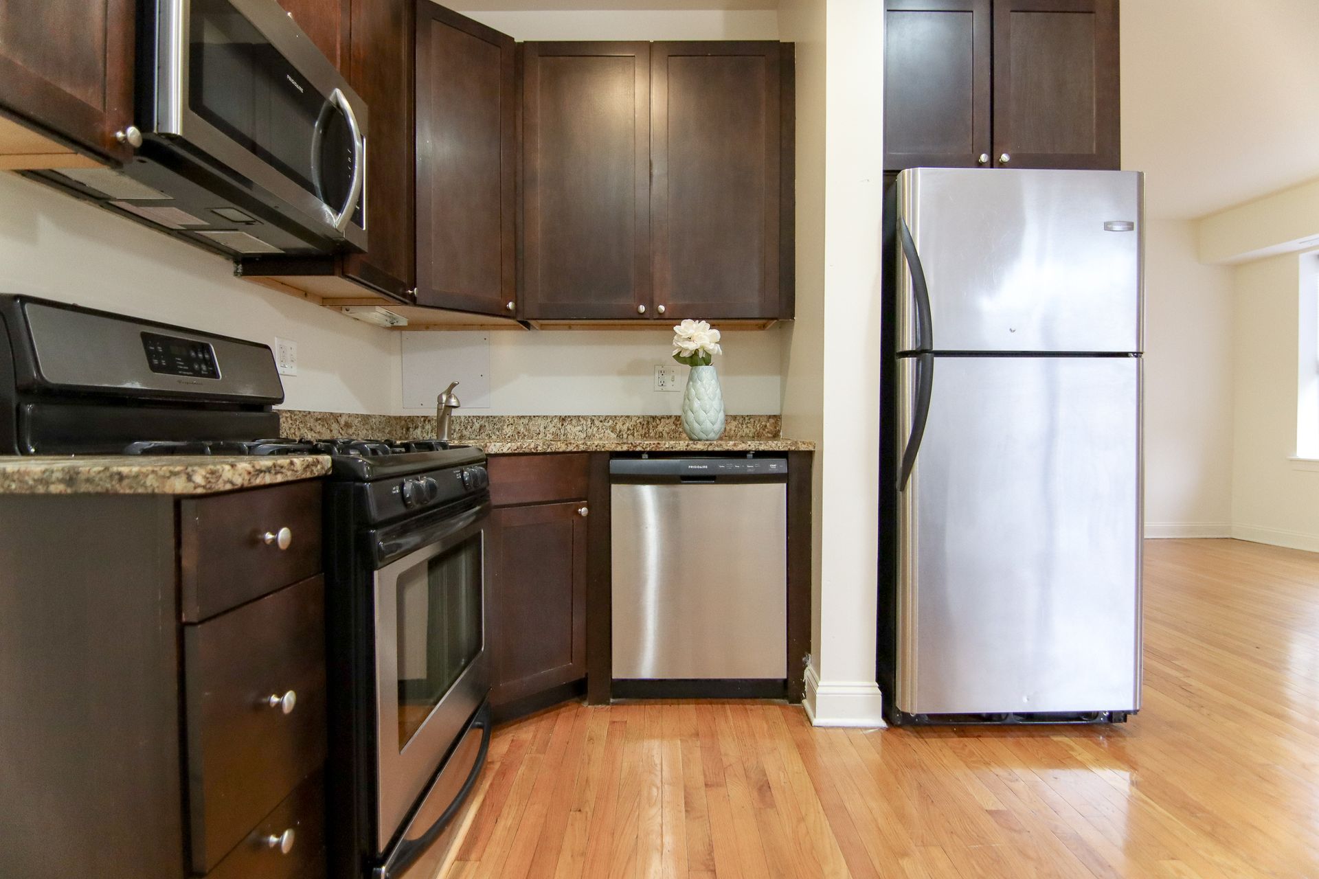 Kitchen with dark brown cabinets, stainless steel appliances, and granite countertops.