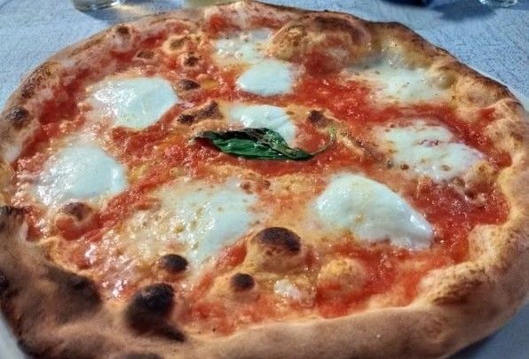 Pizza Margherita con salsa di pomodoro, mozzarella e basilico.