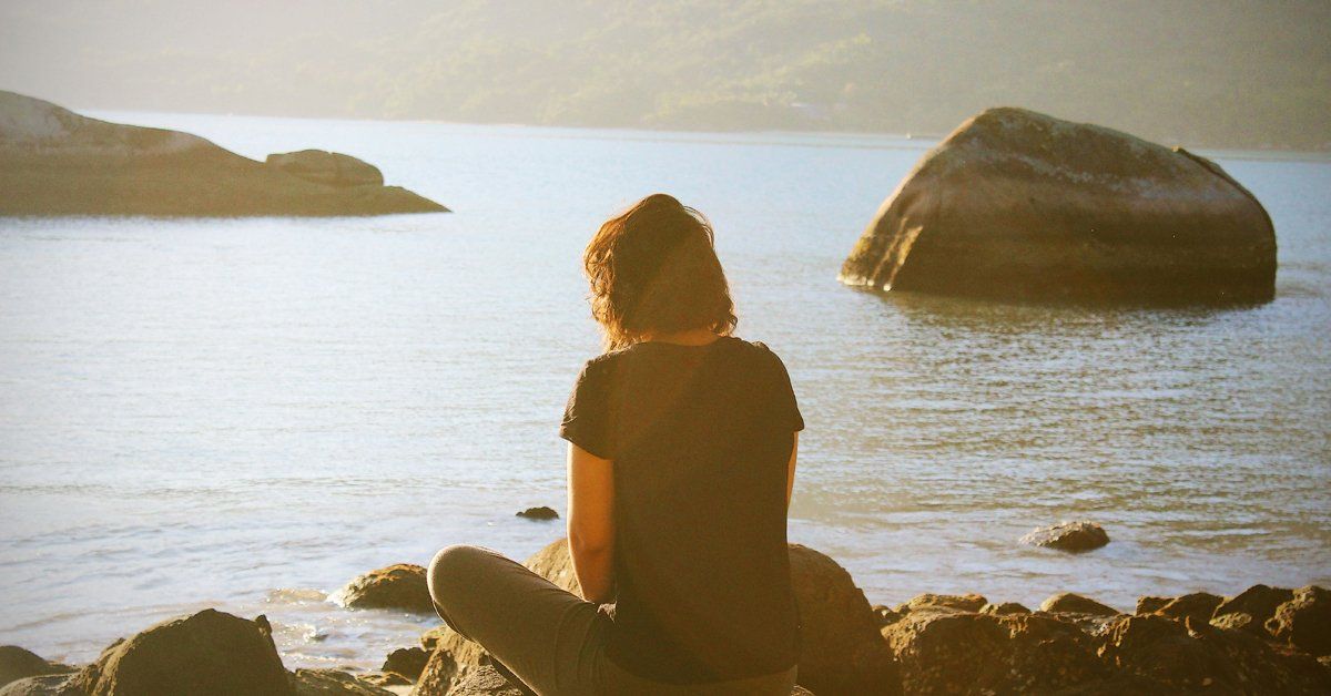 Lady Sitting on a Rock Overlooking Water