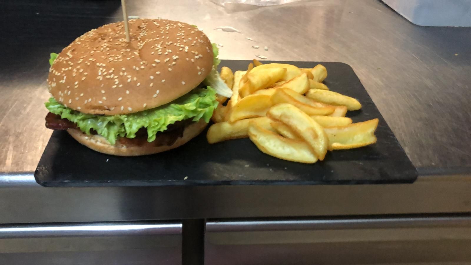 Insalata di pomodori e formaggio con rucola su un piatto, con carta stagnola e pellicola trasparente sullo sfondo.