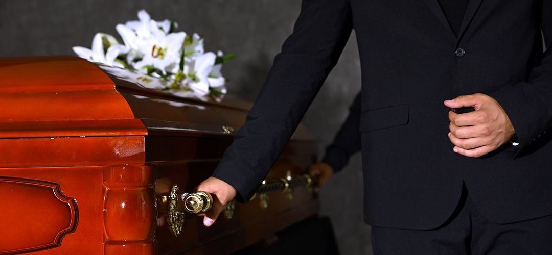 person holding onto a casket on a table