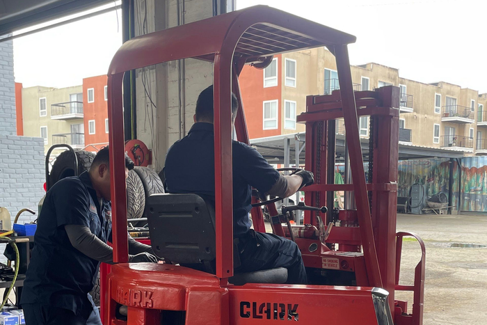 Two people working on a red Clark forklift | Angel's Auto Repair And Service